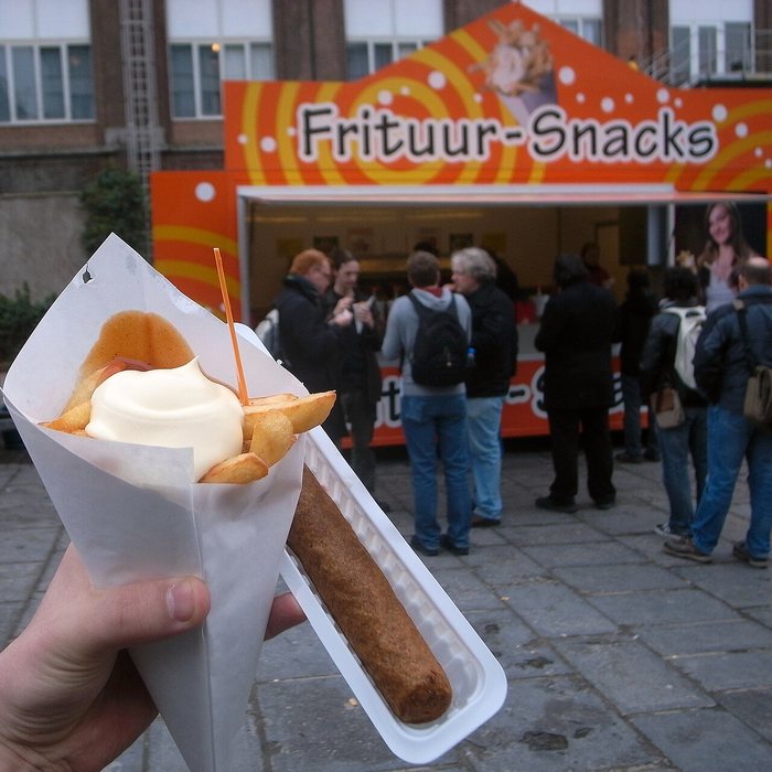 Cucurucho de patatas fritas belgas con mayonesa en un puesto de frituur de Bruselas